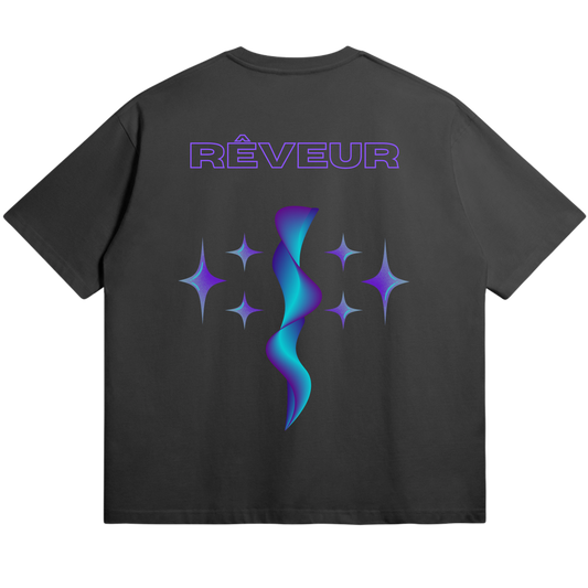 Oversized black streetwear t-shirt “NOVA” by RÊVEUR — minimalist cosmic design featuring blue and purple star shapes with a fluid abstract center.
