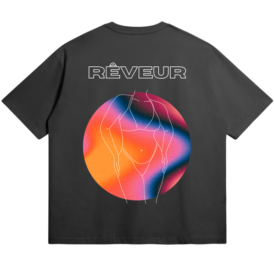 Oversized black streetwear t-shirt “SHE” by RÊVEUR — artistic minimalist line art of a woman’s body with a colorful gradient circle, celebrating creative freedom and body positivity.
